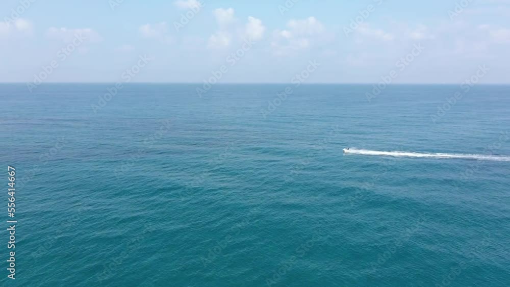 Aerial video of the sea horizon. While a vessel is speeding in (jet ski) Aerial video of the sea horizon. While a vessel is speeding in (jet ski)