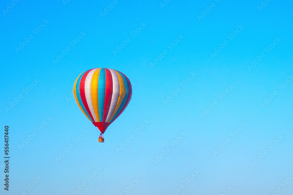 Fototapeta premium a multicolored balloon in a blue sky