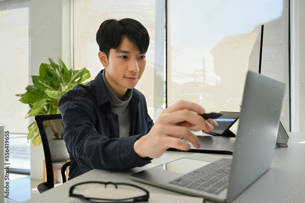 Fototapeta premium Start up businessman pointing on screen, checking online information on his laptop computer