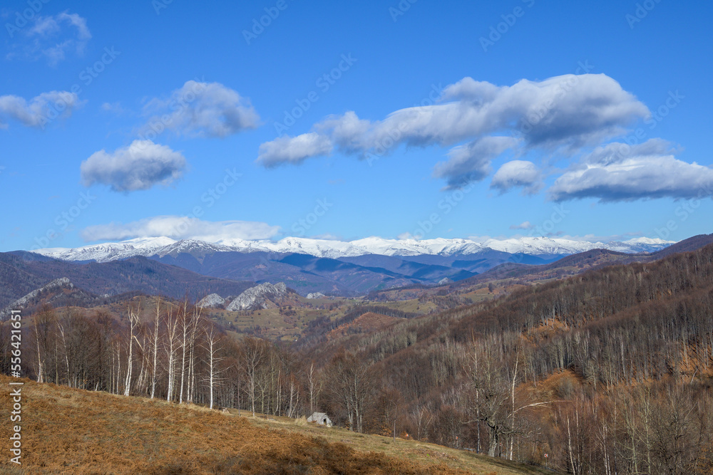 Snow-covered mountains, valleys and hills. Mountains, snow, clouds in the blue sky.