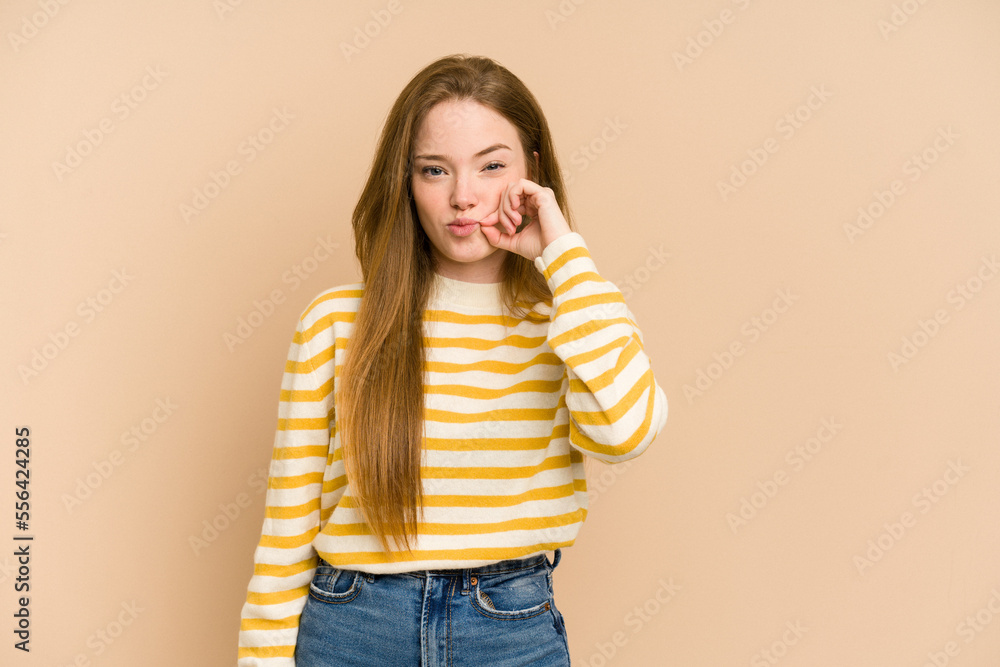 Young redhead woman cut out isolated with fingers on lips keeping a secret.
