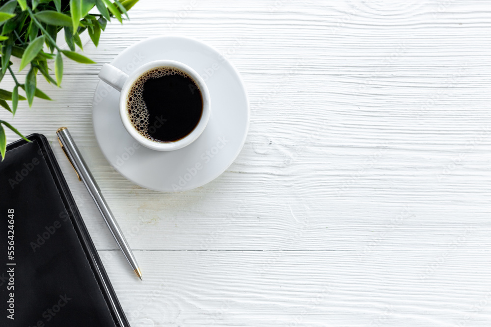 Office table with cup of hot black coffee and notebook Office table with cup of hot black coffee and notebook