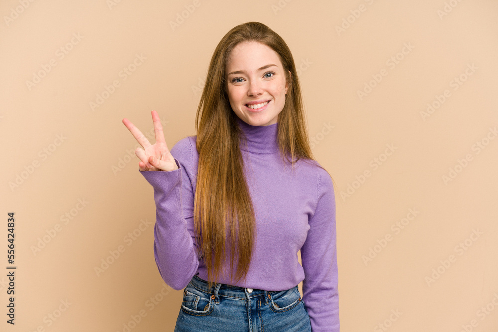 Young redhead woman cut out isolated showing victory sign and smiling broadly. Young redhead woman cut out isolated showing victory sign and smiling broadly.
