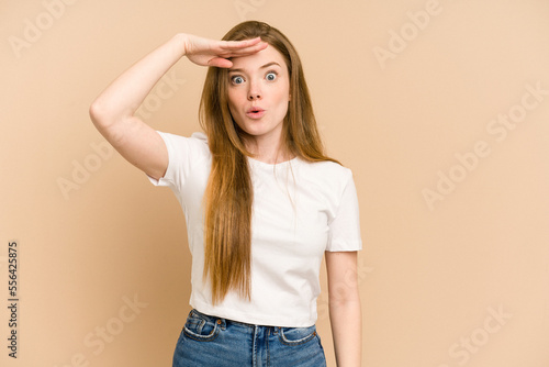 Foto Young redhead woman cut out isolated looking far away keeping hand on forehead