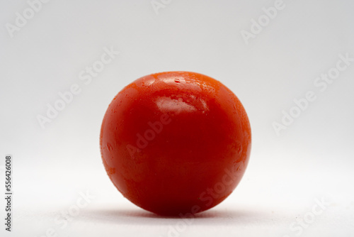 Nahaufnahme einer saftigen roten runde Tomate mit Wassertropfen