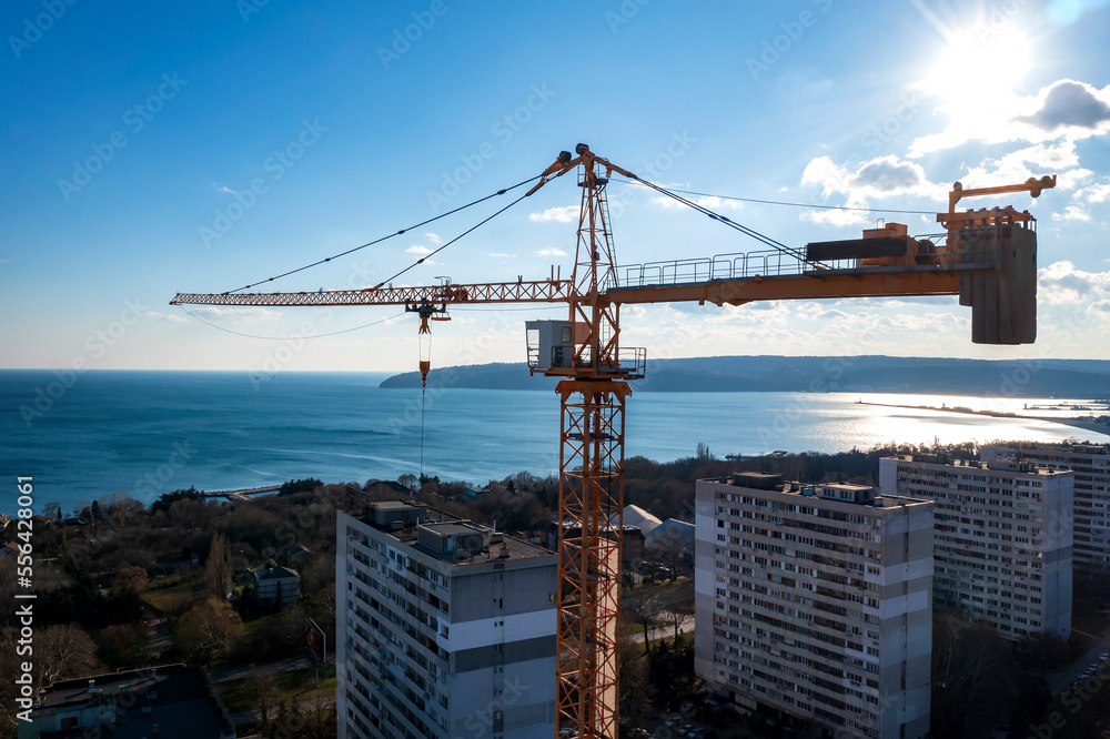 View from a drone to construction tower crane against a blue sky