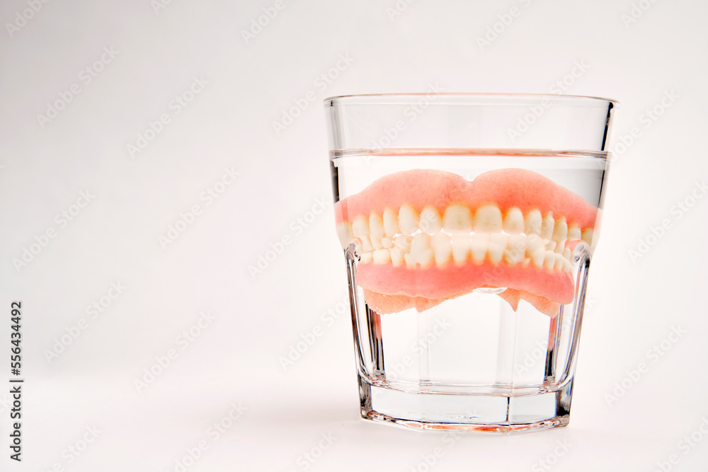Dentures in a glass of water. Dental prosthesis health care Stock Photo