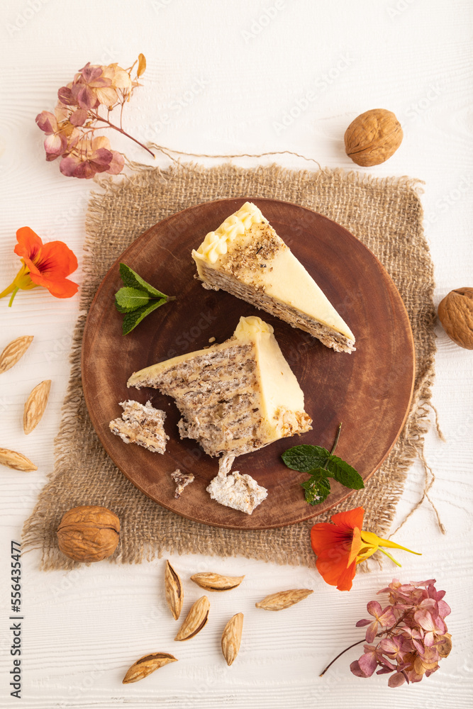 Fototapeta premium Walnut and almond cake on white wooden, top view.