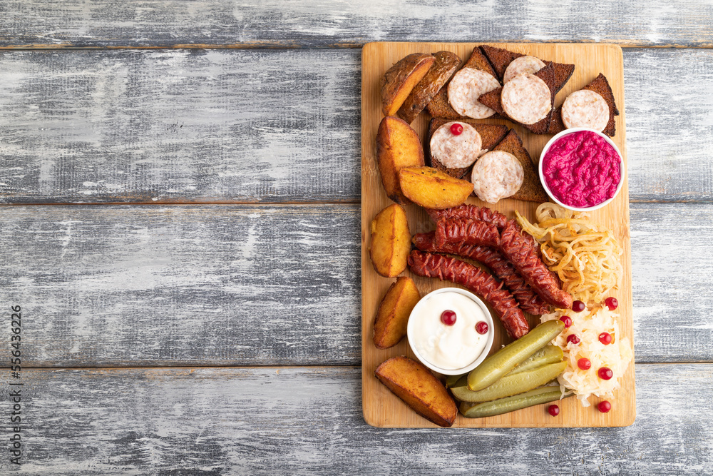 set of snacks: sausages, toast, sauerkraut, marinated onion and cucumber, baked potato. Top view, copy space. set of snacks: sausages, toast, sauerkraut, marinated onion and cucumber, baked potato. Top view, copy space.