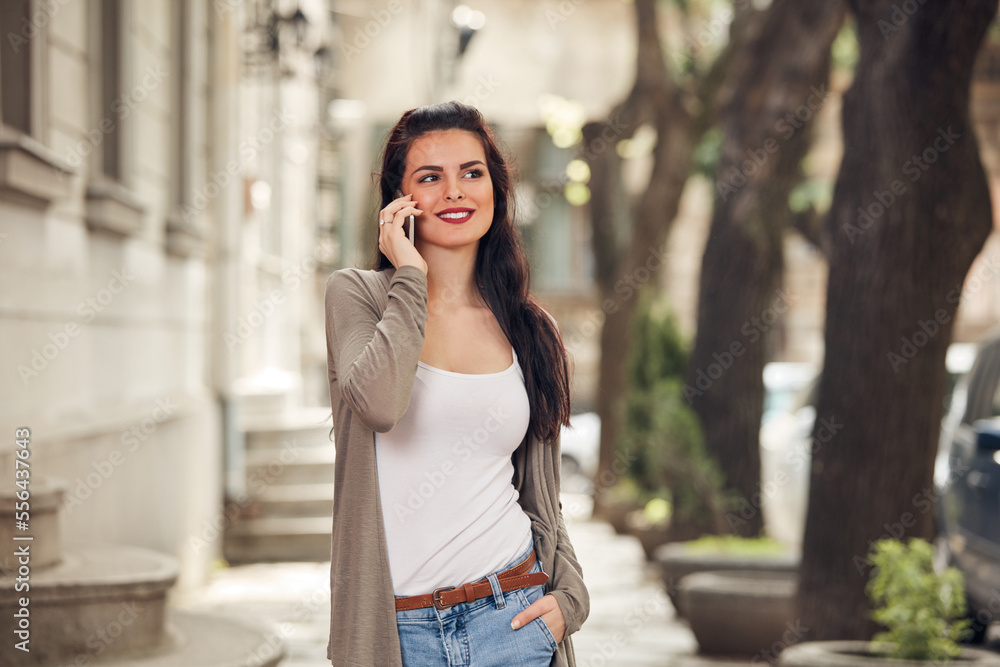 Young cute female using smartphone on the street. Young cute female using smartphone on the street.