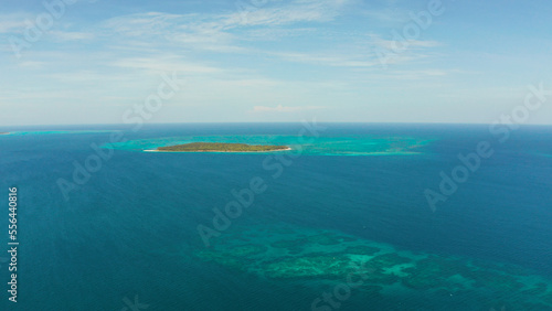 Tropical island with sandy beach by atoll with coral reef and blue sea, aerial view. Patongong Island with sandy beach. Summer and travel vacation concept.