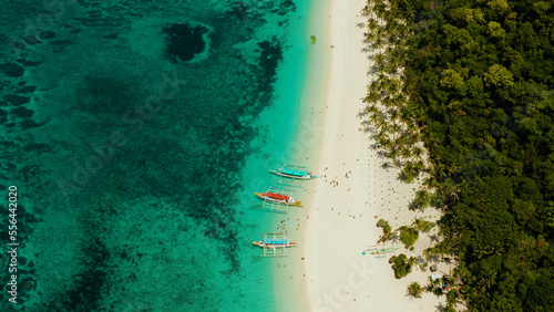 Tropical beach with palm trees and turquoise waters of the coral reef, top view, Puka shell beach. Boracay, Philippines. Seascape with beach on tropical island. Summer and travel vacation concept.