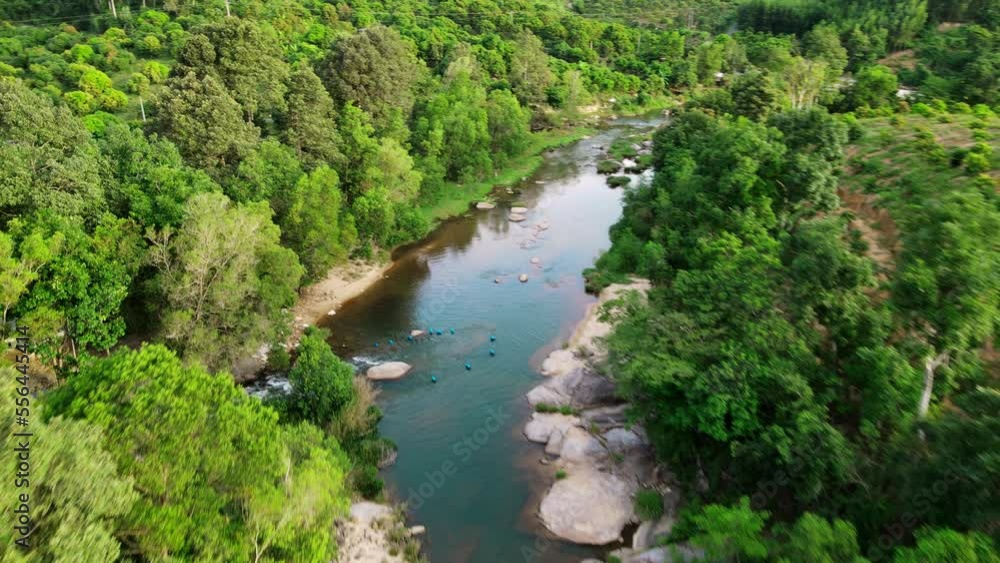 A mountain river in the middle of a green forest with trees and stones on the shore. A mountain river in the middle of a green forest with trees and stones on the shore.