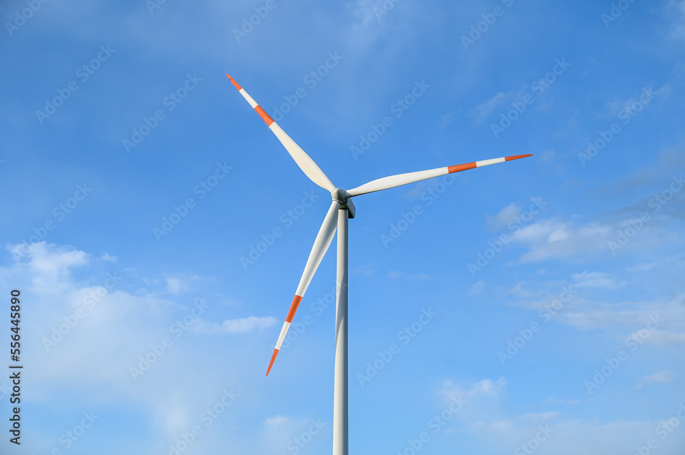Windmills on Wind farm. Wind turbines against blue sky. Producing renewable energy. Windmills on Wind farm. Wind turbines against blue sky. Producing renewable energy.