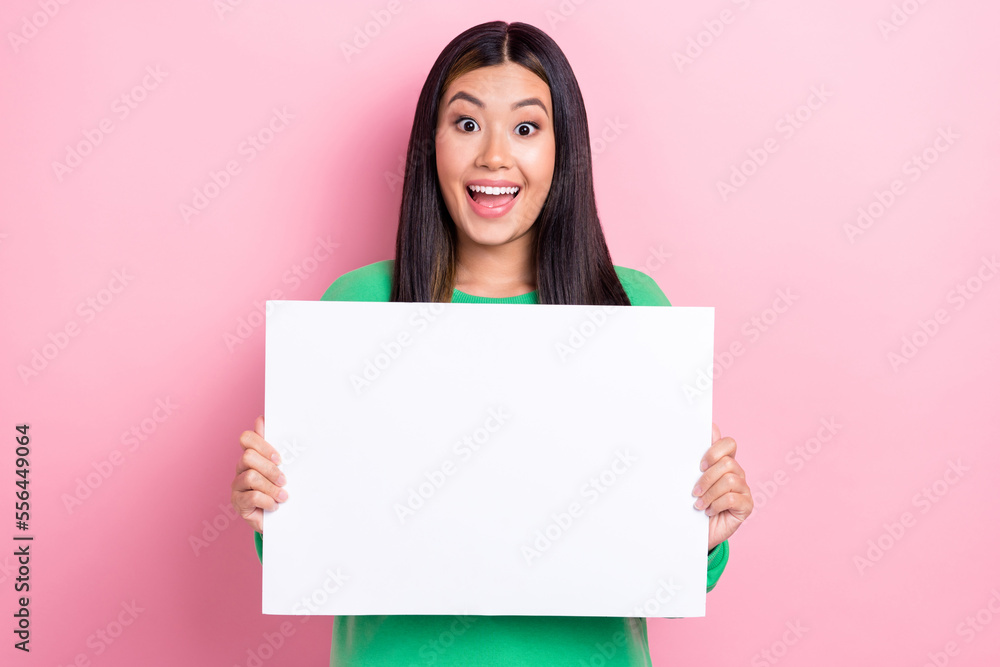 Photo of impressed cute girl dressed green sweatshirt rising white billboard empty space isolated pink color background Photo of impressed cute girl dressed green sweatshirt rising white billboard empty space isolated pink color background