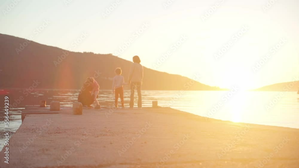 Family on the pier by the sea at sunset Family on the pier by the sea at sunset