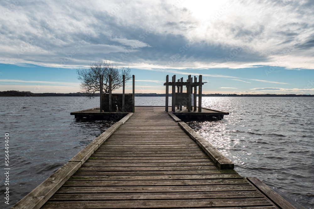 Naklejka premium Cais de madeira sobre o lago num dia nublado de inverno