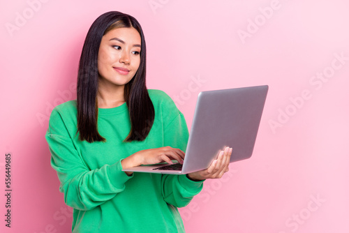 Photo of adorable cute girl dressed green sweatshirt chatting instagram twitter telegram facebook isolated pink color background