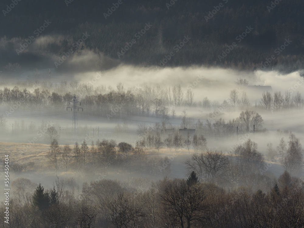 Fototapeta premium Morning fog in the Central Sudetes. The city of Boguszow-Gorce in the fog. Beautiful landscape of the Stone Mountains at sunrise.