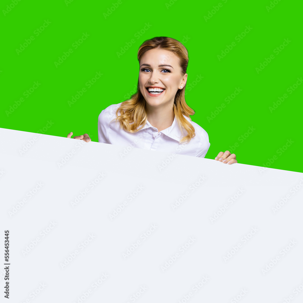 Very happy excited, laughing business woman in white confident clothing standing behind empty area banner signboard. Success and ad concept. Green chroma key background. Square image. Very happy excited, laughing business woman in white confident clothing standing behind empty area banner signboard. Success and ad concept. Green chroma key background. Square image.