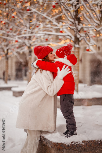 mother and son in warm clothes have fun in winter at a snowy New Year's fair