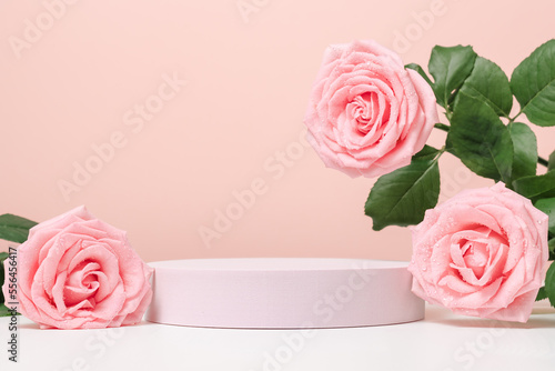 Empty podium with pink roses on pastel pink background to display products, gift or cosmetics.