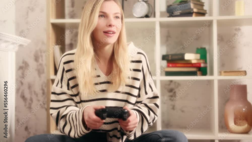 Dreamy shot of beautiful excited young gamer girl in the living room and playing in video games on a console at daytime Happy player woman controlling joystick for video game Dreamy shot of beautiful excited young gamer girl in the living room and playing in video games on a console at daytime Happy player woman controlling joystick for video game