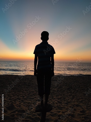 silhouette of a person standing on the beach
