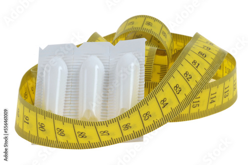 Concept de constipation avec des laxatifs en suppositoires et un mètre souple en gros plan sur fond blanc photo