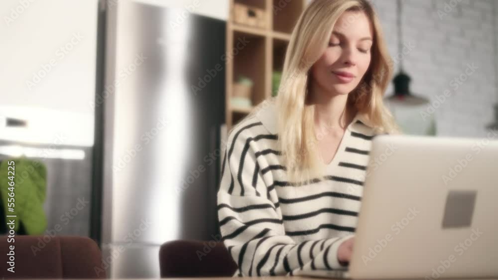 Dreamy shot of attractive young blond woman student freelancer using laptop computer at home Charming blond female doing online job working studying or browsing web with warm sunlight indoors Dreamy shot of attractive young blond woman student freelancer using laptop computer at home Charming blond female doing online job working studying or browsing web with warm sunlight indoors