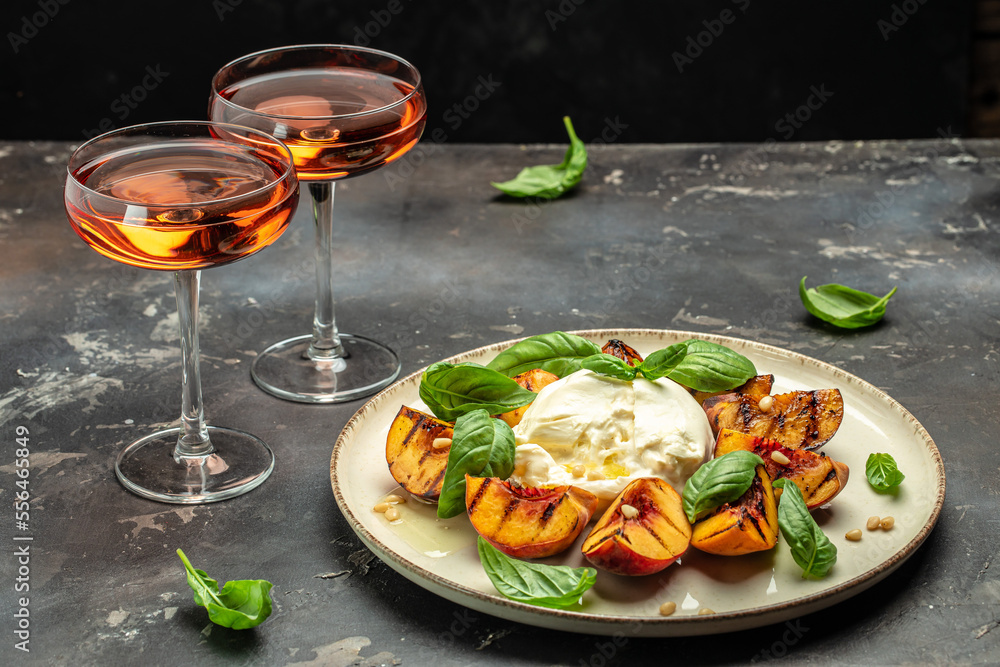 Gourmet Roasted Peaches with Burrata soft cheese, basil and drizzled with honey, with rose wine. Antipasto Dinner or aperitivo party
