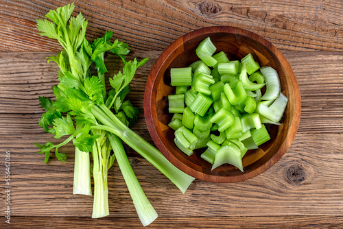 Sliced fresh celery on a wooden plate on wooden background