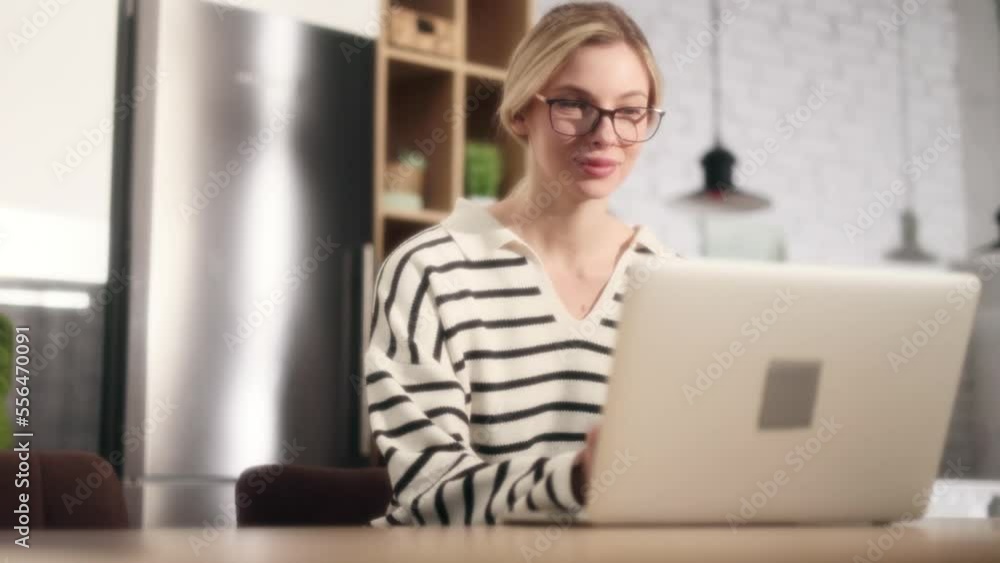 Dreamy shot of attractive young woman student freelancer with glasses using laptop computer at home Charming blond female doing online job working studying or browsing web with warm sunlight indoors Dreamy shot of attractive young woman student freelancer with glasses using laptop computer at home Charming blond female doing online job working studying or browsing web with warm sunlight indoors
