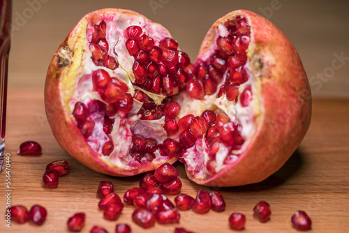 ripe pomegranate seeds on a wooden board