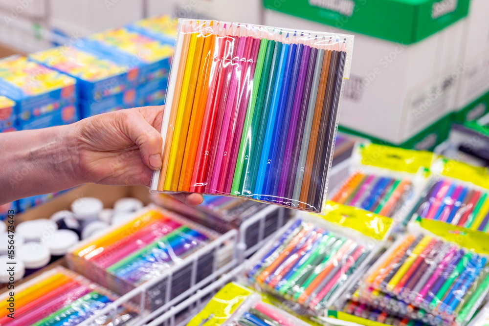 a woman's hand holds a large pack of colored pencils in the stationery department of a supermarket a woman's hand holds a large pack of colored pencils in the stationery department of a supermarket