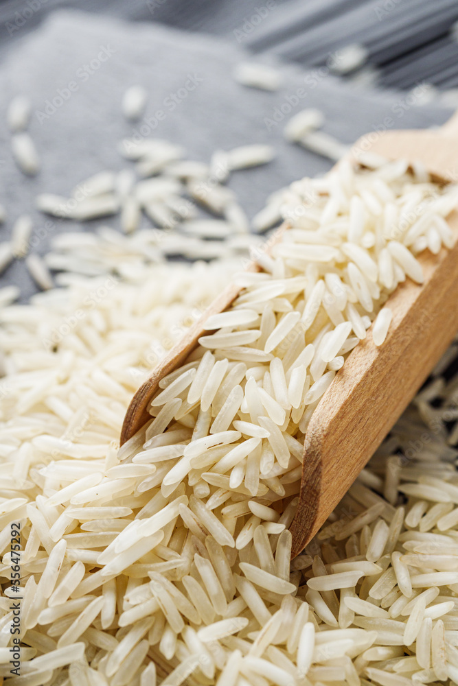 raw basmati rice on a black wooden background raw basmati rice on a black wooden background