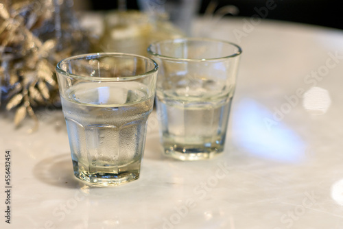 Dos vasos de agua fresca potable sobre mesa de mármol blanco. 