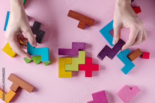 Different colorful shapes wooden blocks on pink background