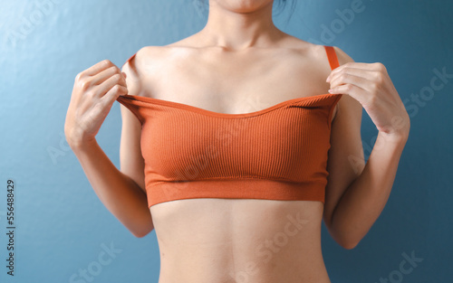 Close up pretty asian model with orange bra nice body isolated on background.