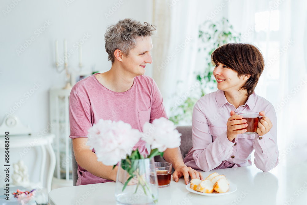 Smiling young man and woman having Breakfast And having fun together at home kitchen with light interior background. Family time. Happy couple in love enjoying each other at their home. Smiling young man and woman having Breakfast And having fun together at home kitchen with light interior background. Family time. Happy couple in love enjoying each other at their home.