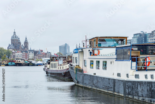 Pleasure ships on a canal in Amsterdam on a cloudy day. Traditions and tourism.
