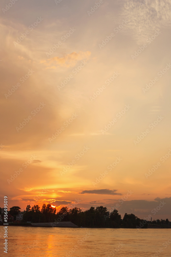 a sky with golden clouds beautifully illuminated by the sun over a wide river