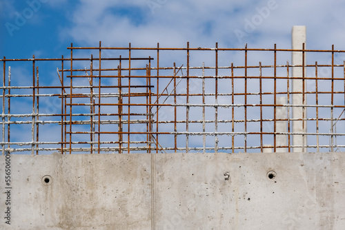 Interessantes Detail einer halbfertigen Stahlbetonmauer auf einer großen Baustelle mit blauem Himmel und selektivem Fokus photo