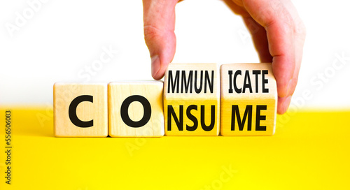 Consume or communicate symbol. Concept word Consume or Communicate on wooden cubes. Beautiful yellow table white background. Businessman hand. Business consume communicate concept. Copy space.