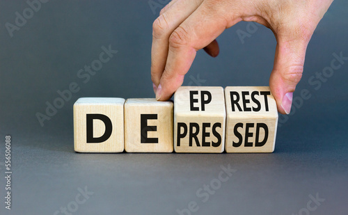 Depressed or deep rest symbol. Concept word Depressed or Deep rest on wooden cubes. Beautiful grey table grey background. Businessman hand. Medical and depressed or deep rest concept. Copy space.