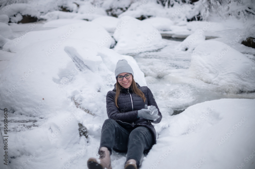Woman in winter jacket walking in snowy winter forest, snowy winter day Woman in winter jacket walking in snowy winter forest, snowy winter day