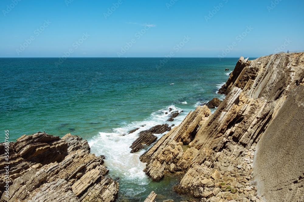 Beautiful landscape of the Penedo da Saudade Lighthouse in Sao Pedro de Moel, Portugal with the cliffs and ocean waves in the foreground Beautiful landscape of the Penedo da Saudade Lighthouse in Sao Pedro de Moel, Portugal with the cliffs and ocean waves in the foreground