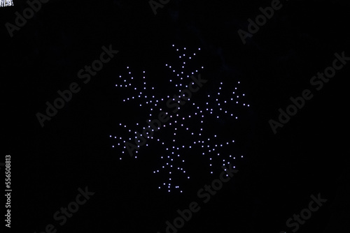 A drone lightshow arranged in the shape of a snowflake photo