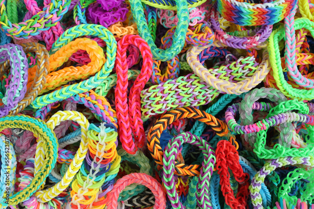 Background - various kinds of colorful bracelets, braided from rubber. View from above