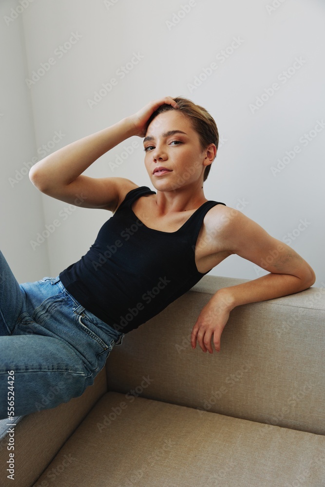 Obraz premium Young woman with short haircut hair having fun at home on the couch smile and happiness, vacation at home, natural posing without filters, free copy space